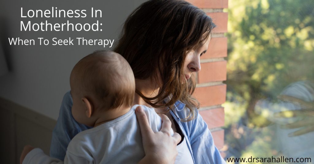 mother holding baby looking out of the window feeling lonely